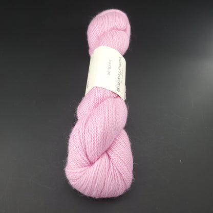 Echeveau de laine Baby Alpaca de BC Garn de couleur 10 rose sur fond noir.