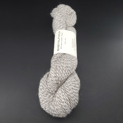 Echeveau de laine Baby Alpaca de BC Garn de couleur 102 silvermarled undyed sur fond noir.
