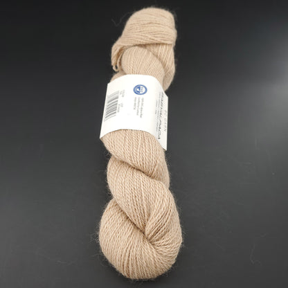 Echeveau de laine Baby Alpaca de BC Garn de couleur 109 creme undyed sur fond noir.