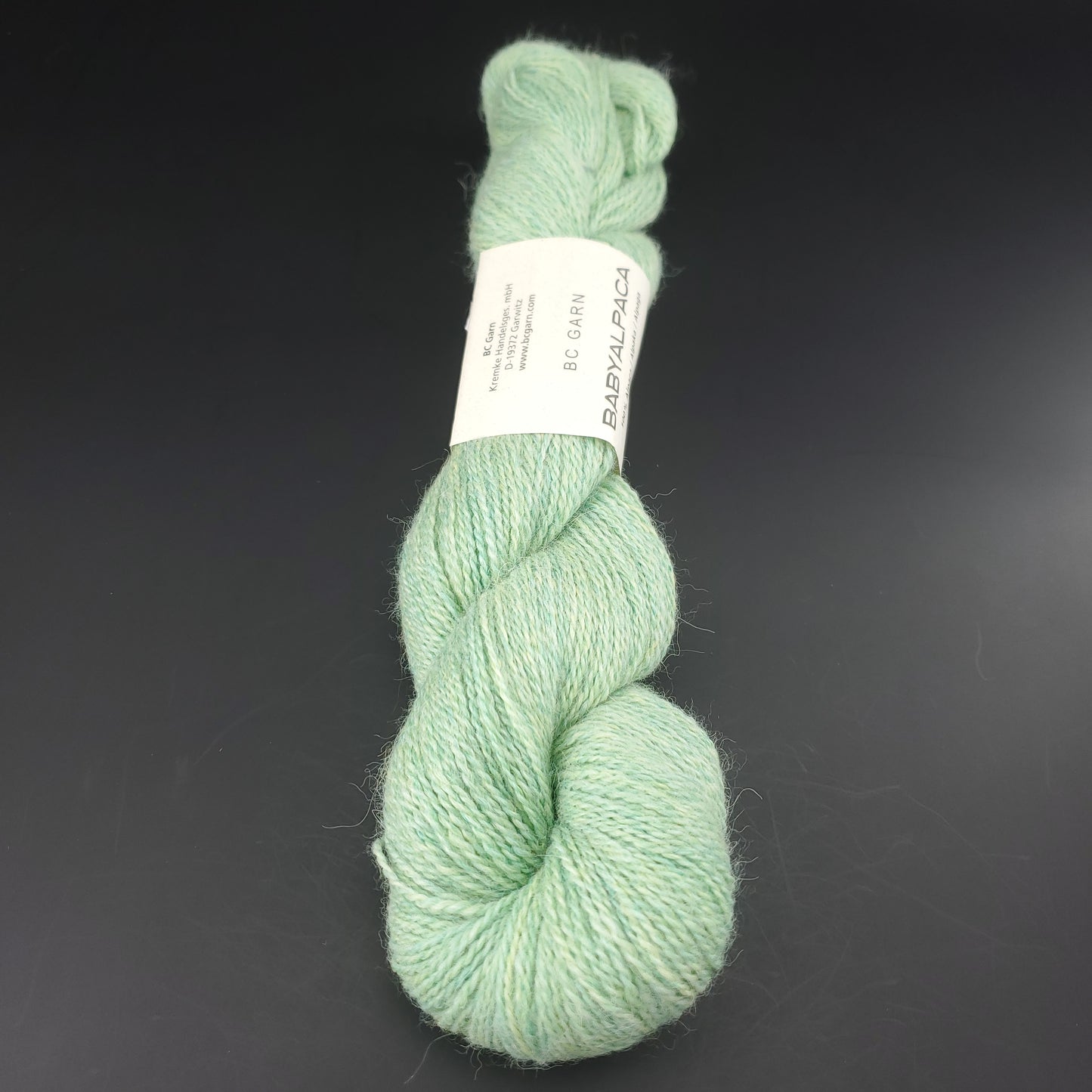 Echeveau de laine Baby Alpaca de BC Garn de couleur 118 peppermint sur fond noir.