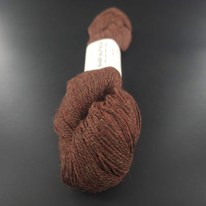 Echeveau de laine Baby Alpaca de BC Garn de couleur 129 brown melange sur fond noir.