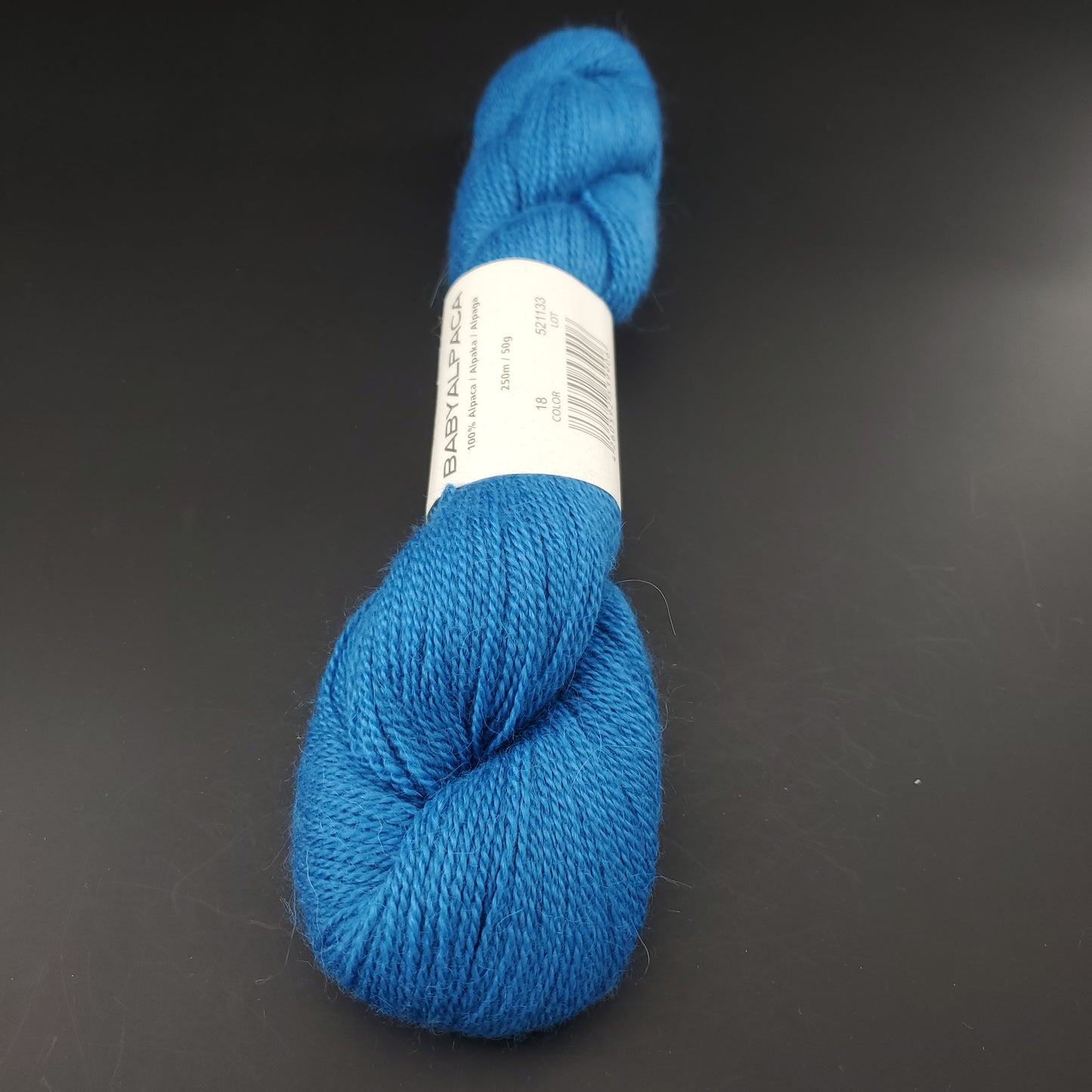 Echeveau de laine Baby Alpaca de BC Garn de couleur 18 ocean sur fond noir.
