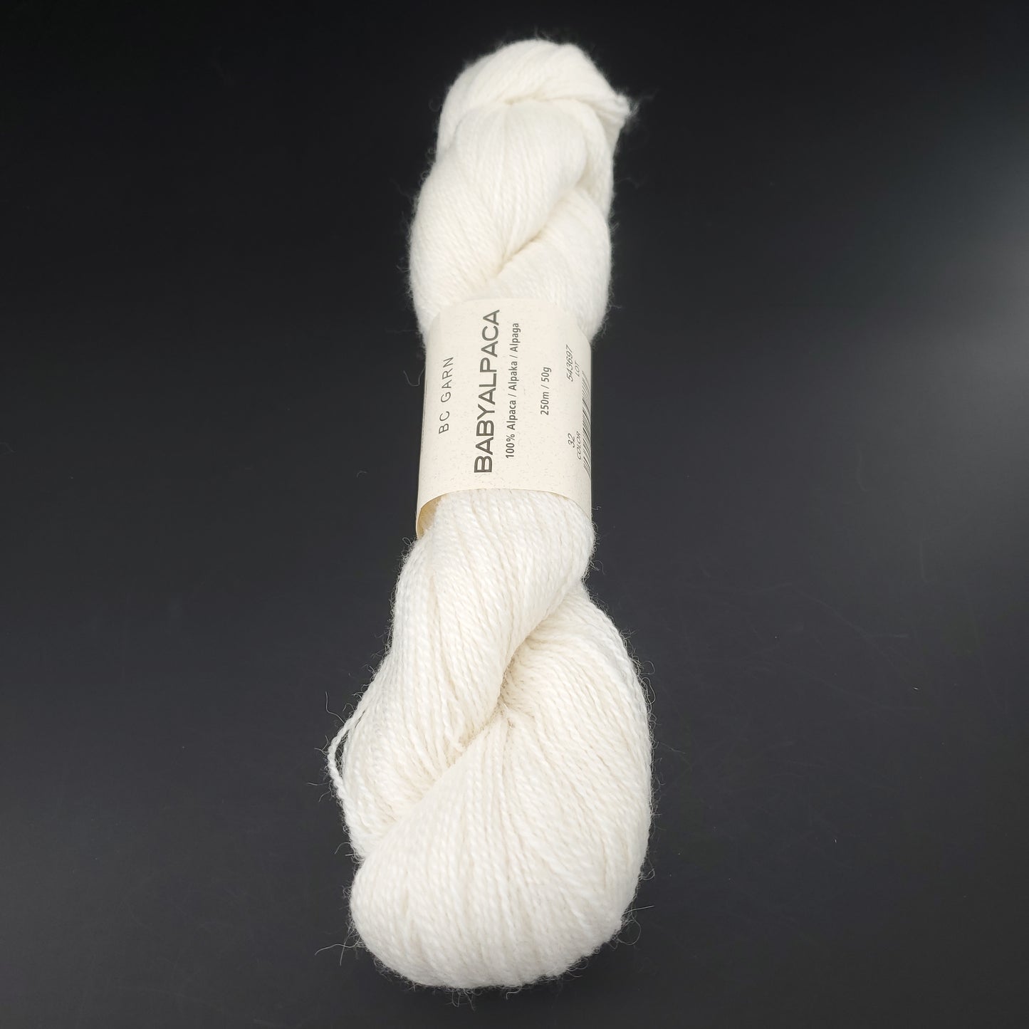 Echeveau de laine Baby Alpaca de BC Garn de couleur 32 snow white sur fond noir.