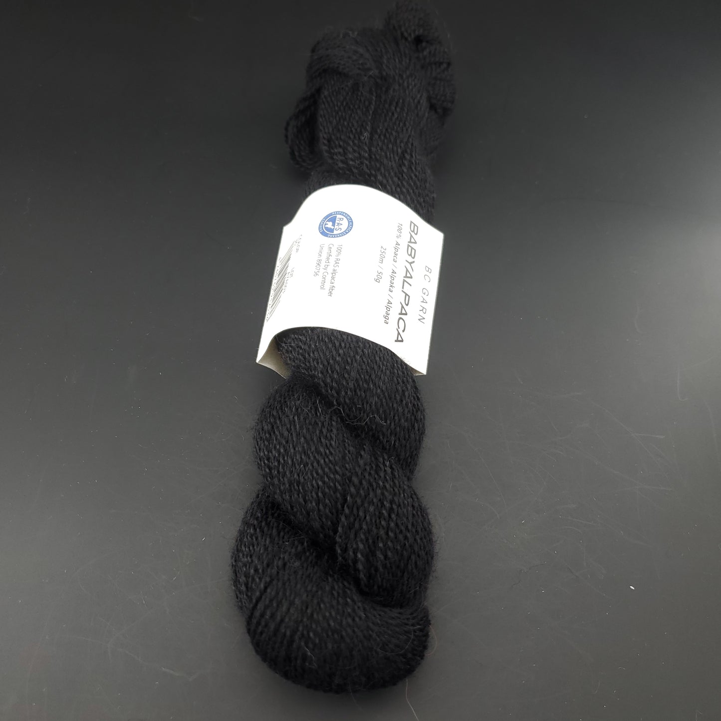 Echeveau de laine Baby Alpaca de BC Garn de couleur 36 black sur fond noir.