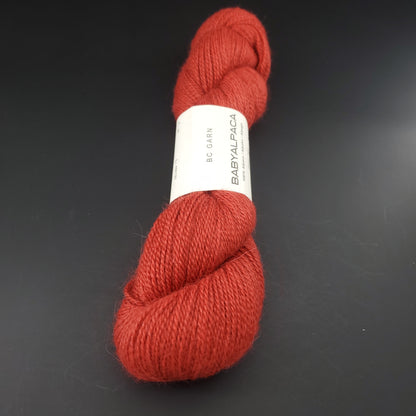 Echeveau de laine Baby Alpaca de BC Garn de couleur 39 brick red sur fond noir.