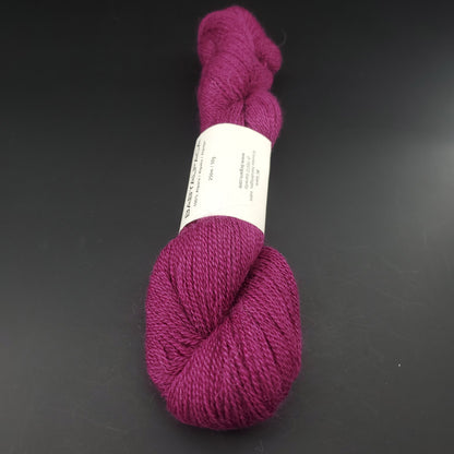 Echeveau de laine Baby Alpaca de BC Garn de couleur 40 plum sur fond noir.