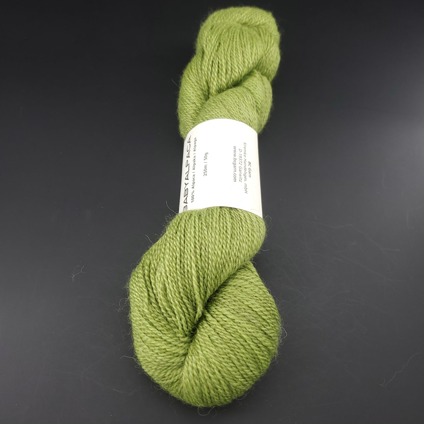 Echeveau de laine Baby Alpaca de BC Garn de couleur 45 light green sur fond noir.