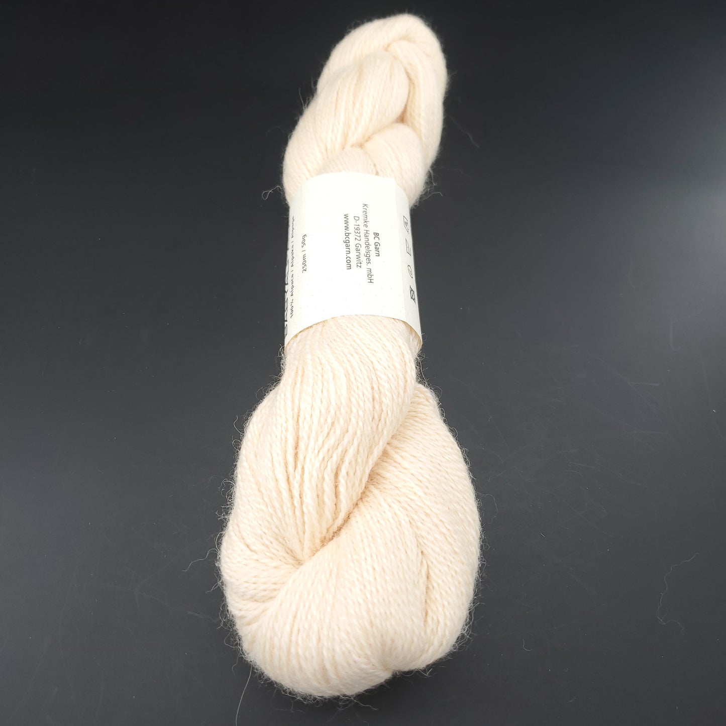 Echeveau de laine Baby Alpaca de BC Garn de couleur 66 vanilla sur fond noir.