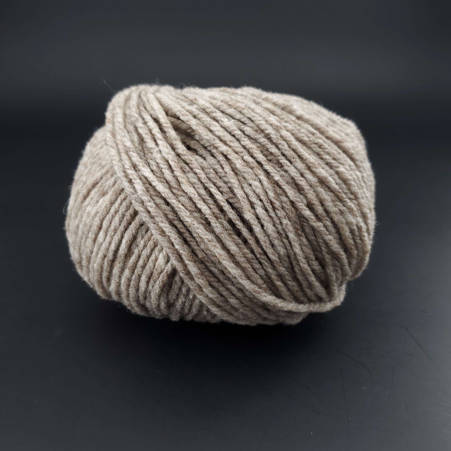 Pelote de laine Fonty Fado de couleur 661 beige sur fond noir.