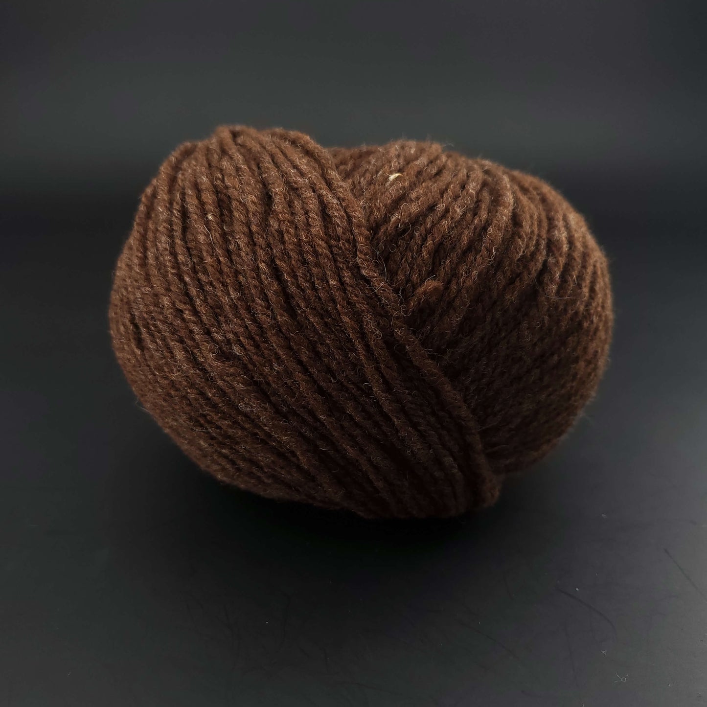 Pelote de laine Fonty Fado de couleur 664-brun foncé écru sur fond noir.