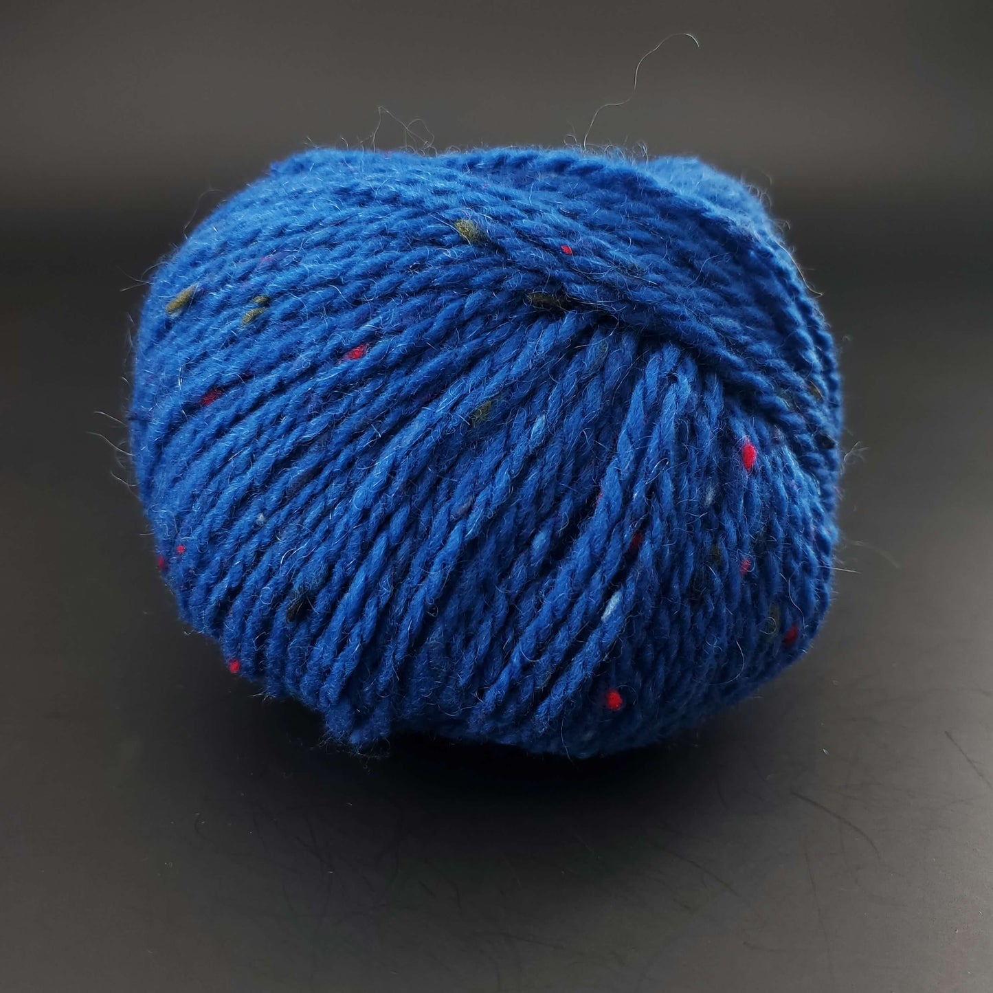 Pelote de laine Fonty Super Tweed de couleur 07 bleu intense sur fond noir