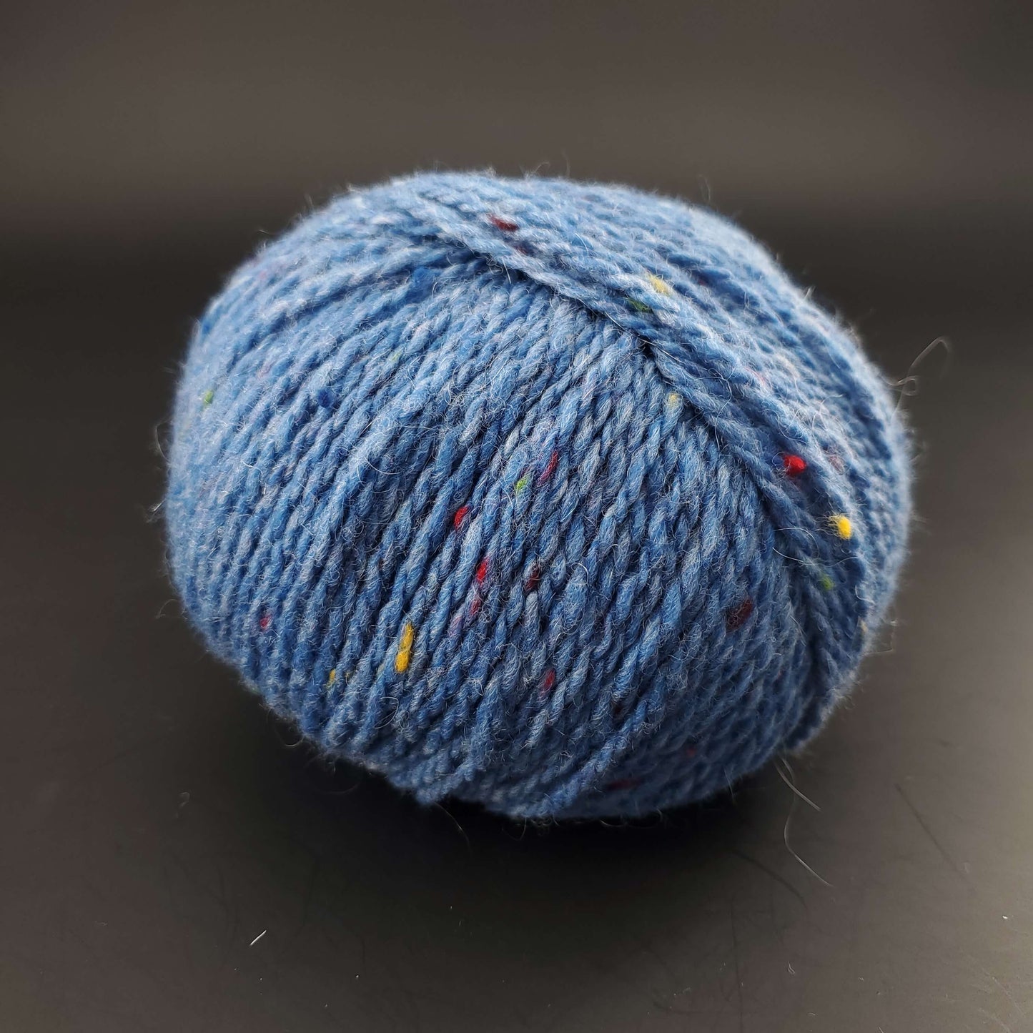 Pelote de laine Fonty Super Tweed de couleur 08 bleu moyen sur fond noir