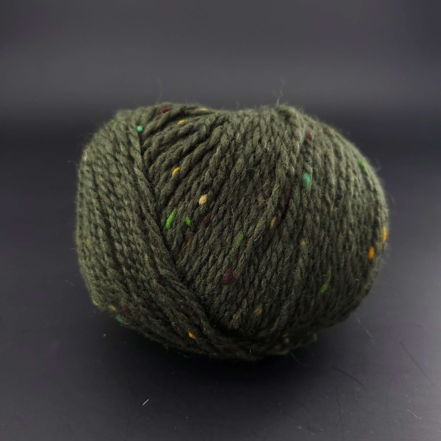 Pelote de laine Fonty Super Tweed de couleur 10 vert foncé sur fond noir