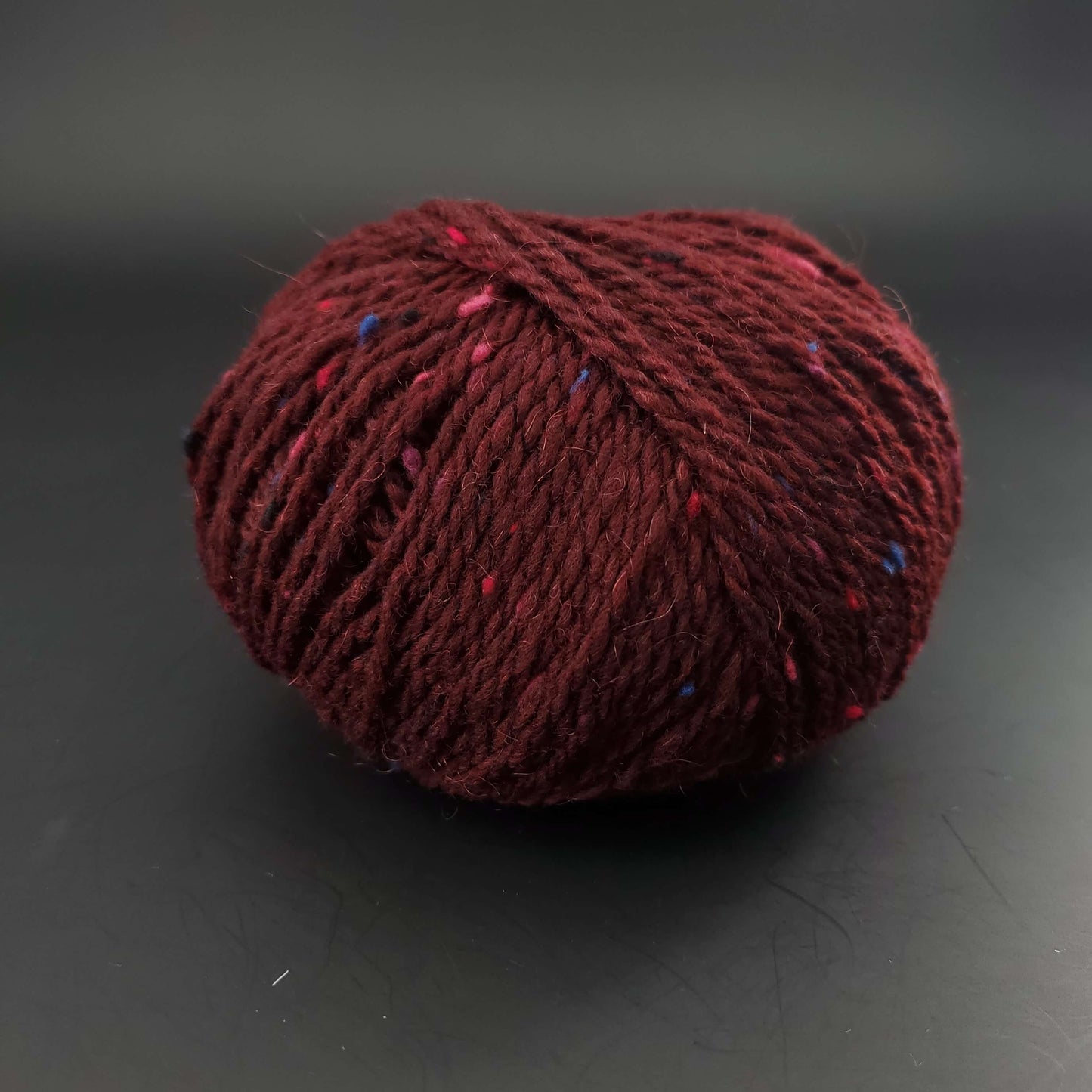Pelote de laine Fonty Super Tweed de couleur 13 bordeaux sur fond noir