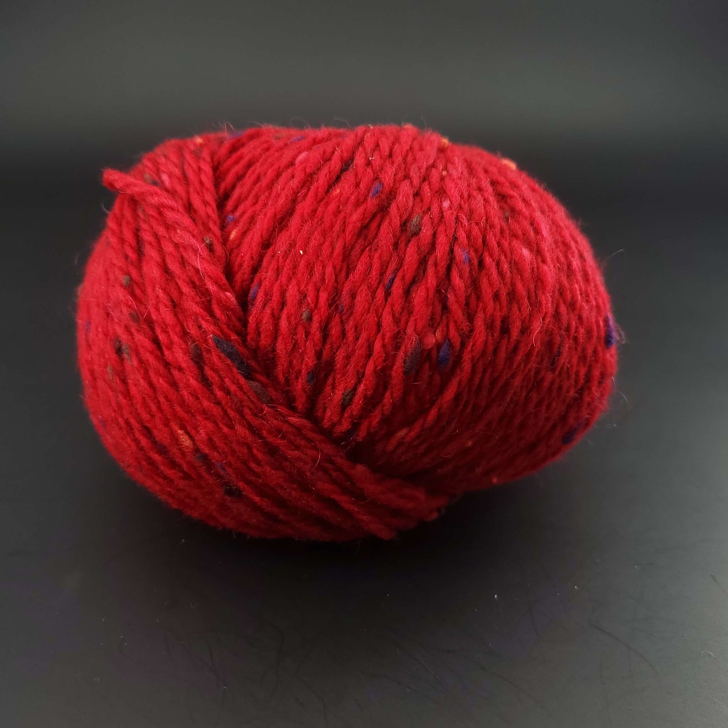 Pelote de laine Fonty Super Tweed de couleur 16 rouge intense sur fond noir
