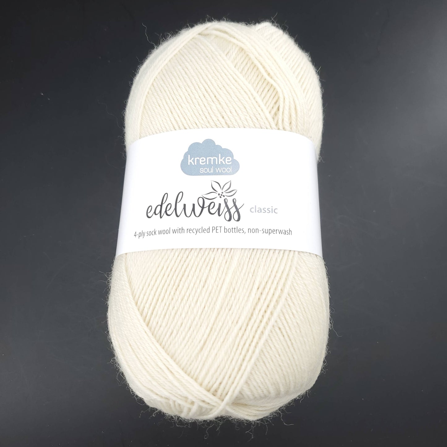 pelote de laine edelweiss classic de marque kremke de coloris 400 ecru pour tricot et crochet sur fond noir