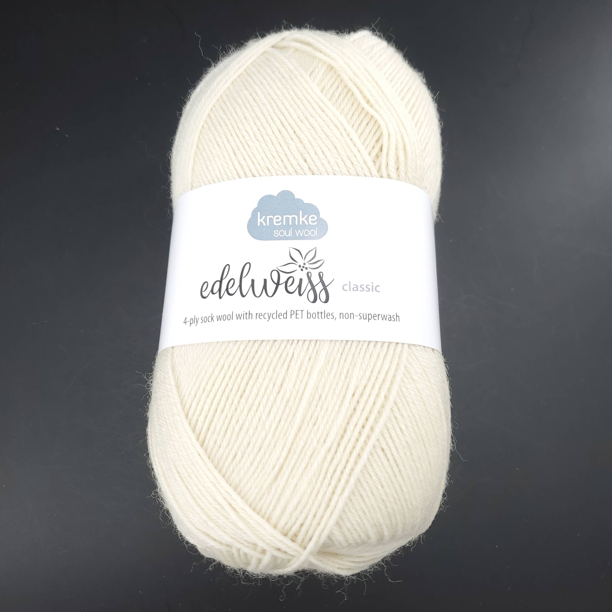 pelote de laine edelweiss classic de marque kremke de coloris 400 ecru pour tricot et crochet sur fond noir