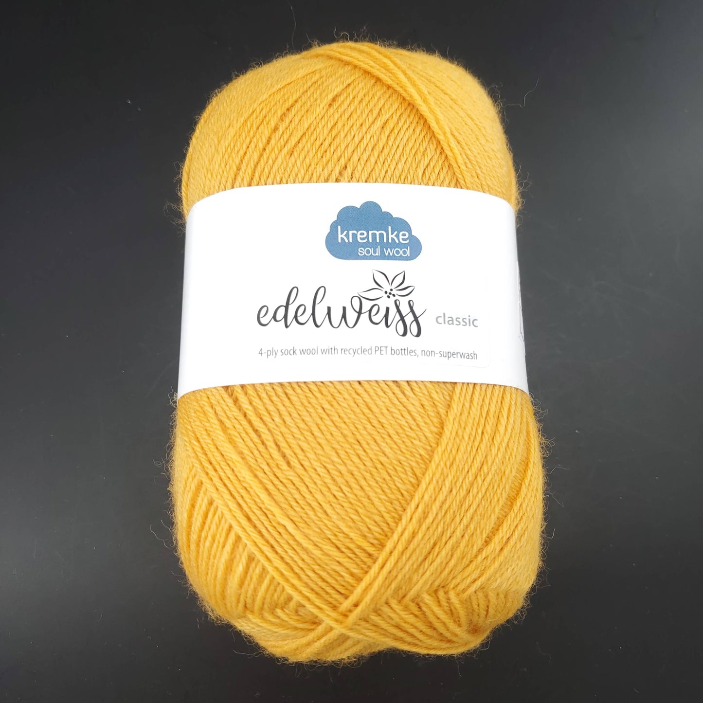 pelote de laine edelweiss classic de marque kremke de coloris 407 jaune soleil pour tricot et crochet sur fond noir