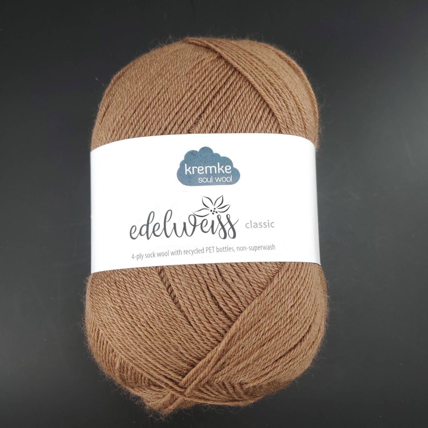 pelote de laine edelweiss classic de marque kremke de coloris 411 noisette pour tricot et crochet sur fond noir