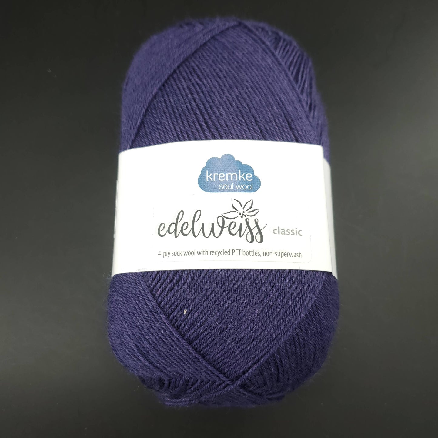 pelote de laine edelweiss classic de marque kremke de coloris 422 bleu marine pour tricot et crochet sur fond noir