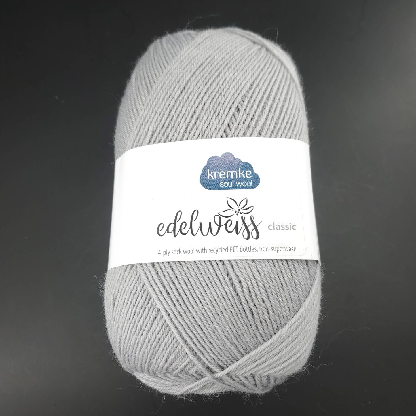 pelote de laine edelweiss classic de marque kremke de coloris 423 gris clair pour tricot et crochet sur fond noir
