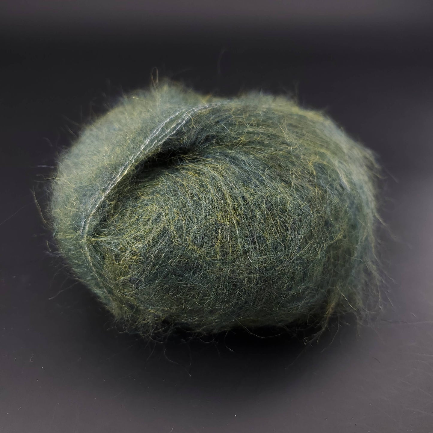 pelote de laine kremke marled silky kid 010 vert foncé sur fond noir