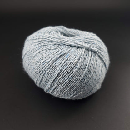 pelote de coton recyclé kremke reborn denim uni coloris 140 bleu layette sur fond noir pour tricot et crochet