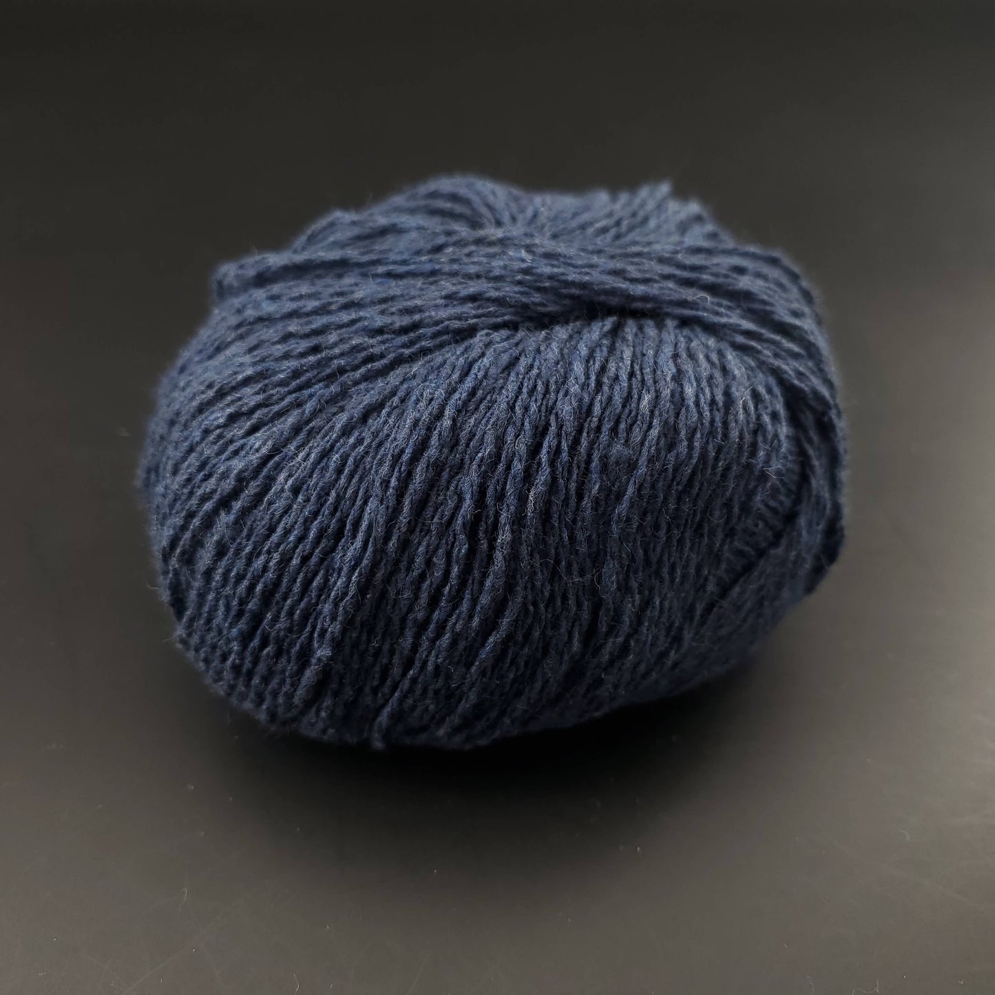pelote de coton recyclé kremke reborn denim uni coloris 147 bleu nuit sur fond noir pour tricot et crochet