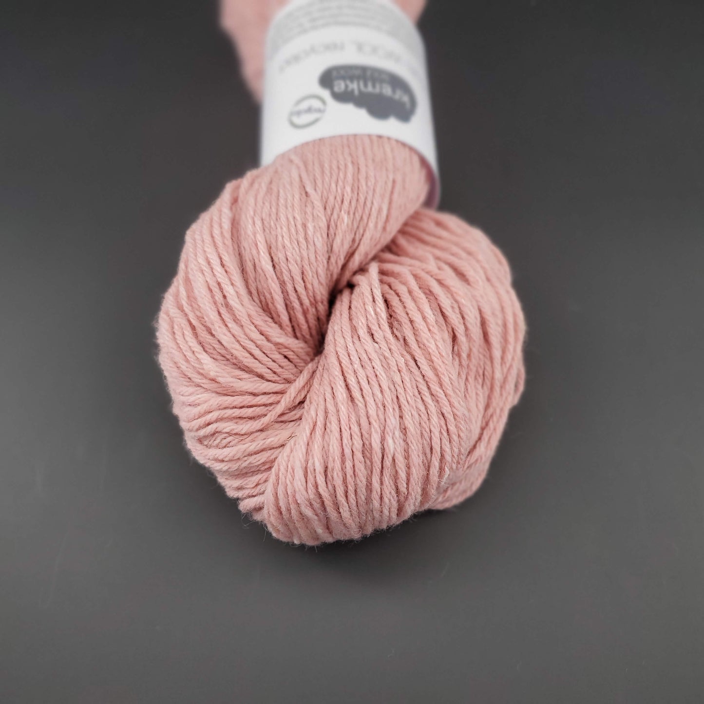 Echeveau de laine Kremke Reborn Wool de couleur 03 (pastel pink), sur fond noir, pour tricot et crochet.
