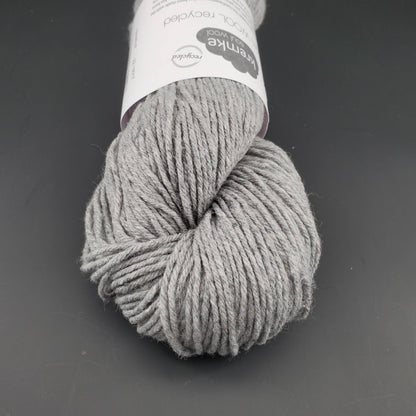Echeveau de laine Kremke Reborn Wool de couleur 22 light grey, sur fond noir, pour tricot et crochet.