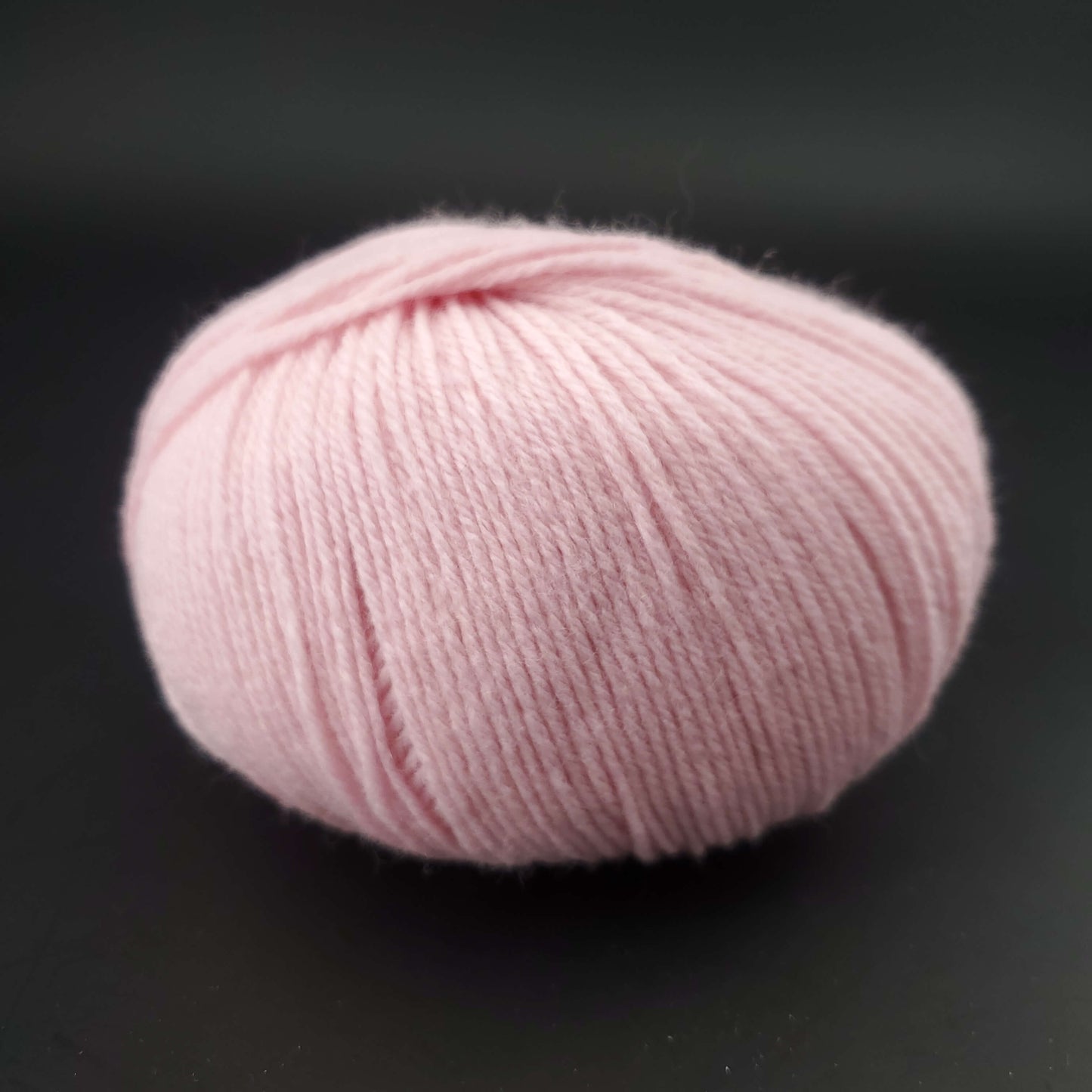Pelote de laine the merry merino 220 de kremke coloris 10 rose poudré sur fond noir