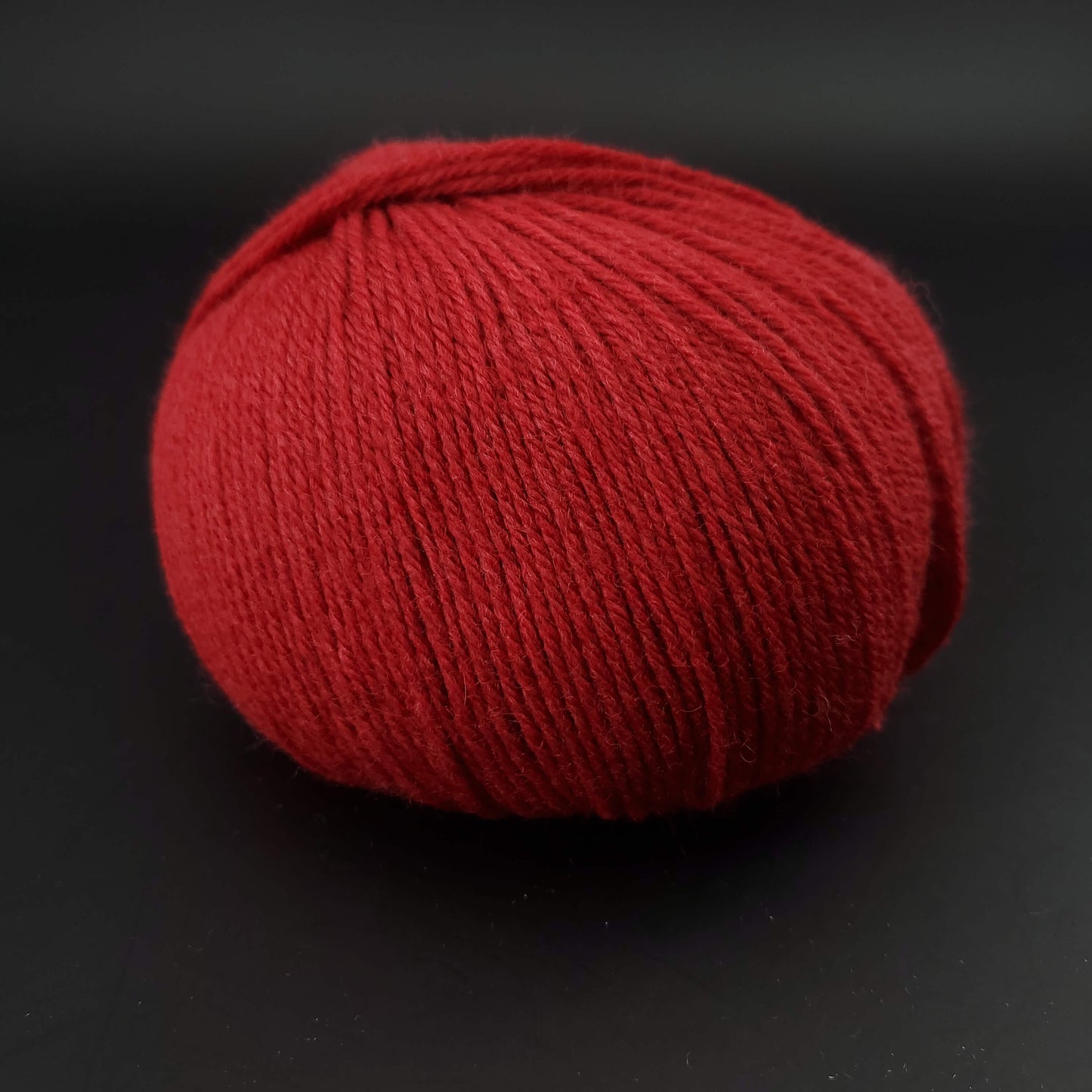 Pelote de laine the merry merino 220 de kremke coloris 12 rouge sur fond noir