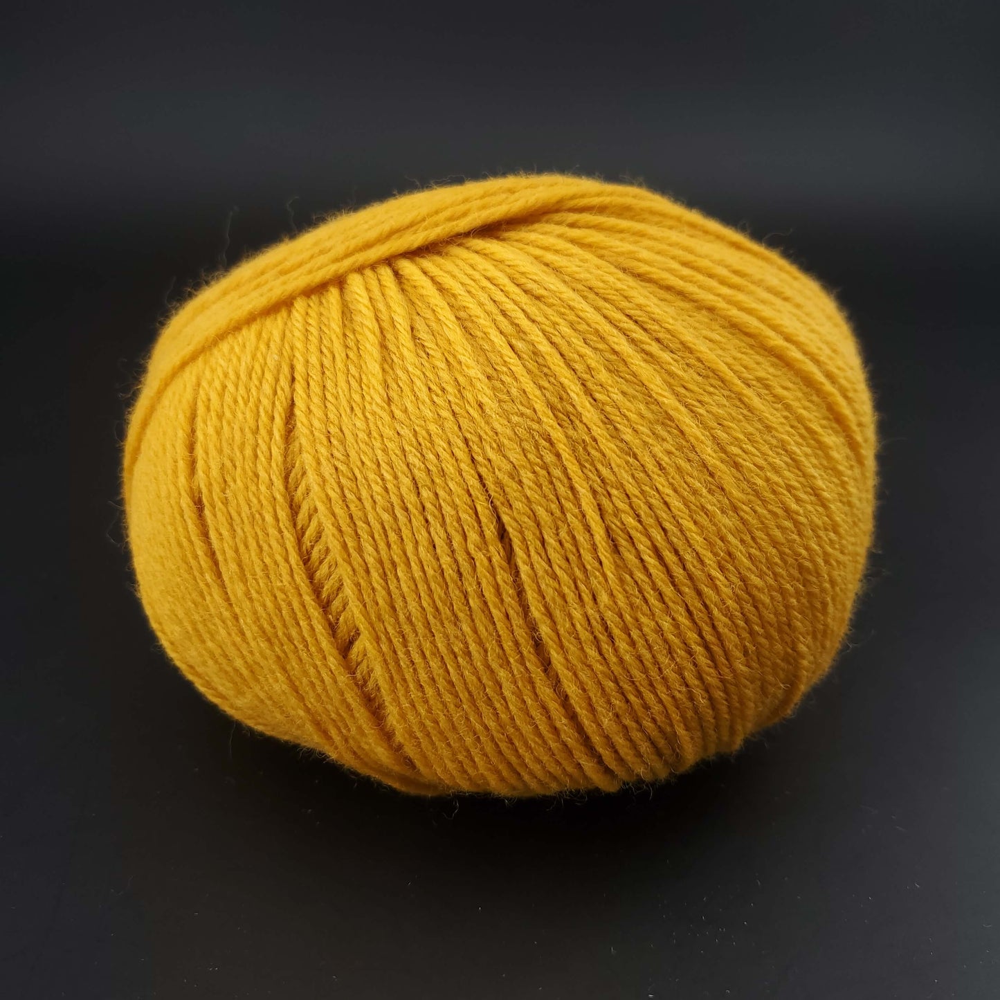 Pelote de laine the merry merino 220 de kremke coloris 13 jaune sur fond noir