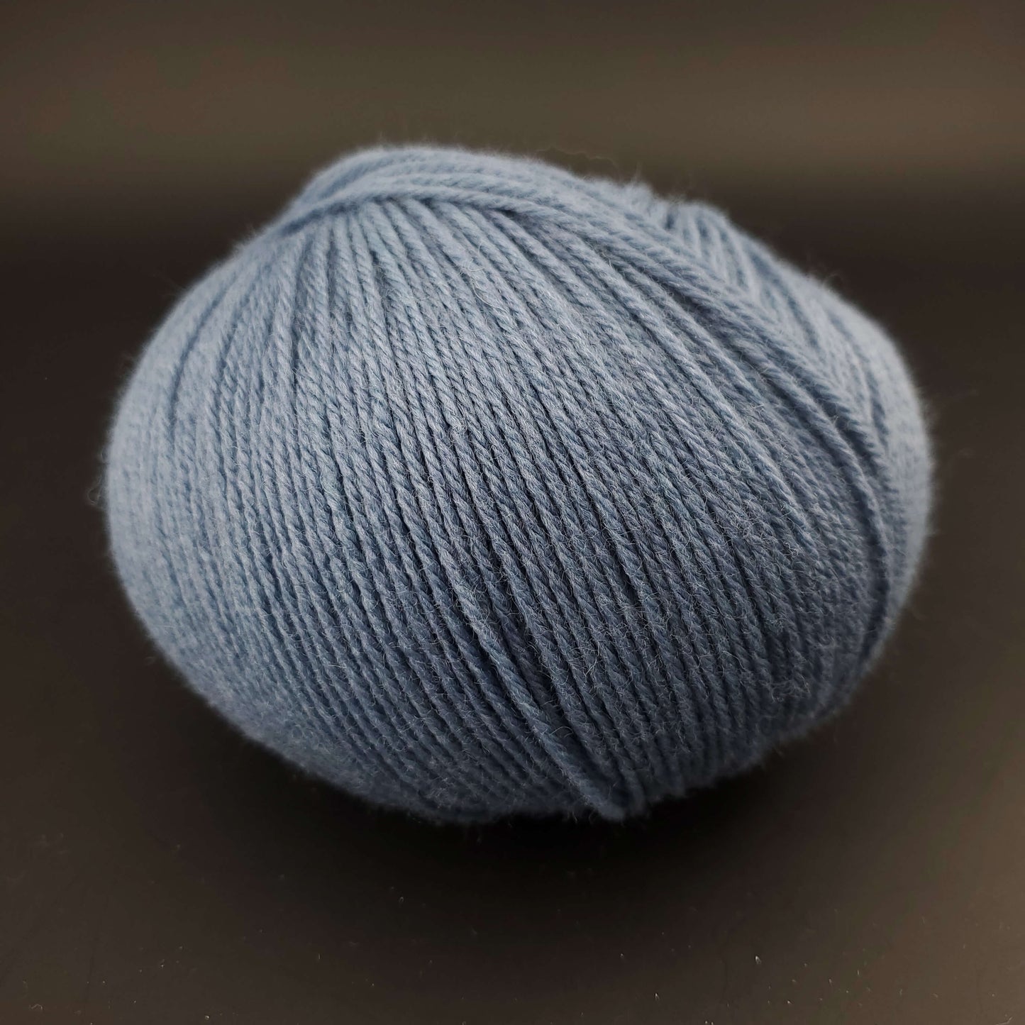Pelote de laine the merry merino 220 de kremke coloris 24 bleu jean sur fond noir
