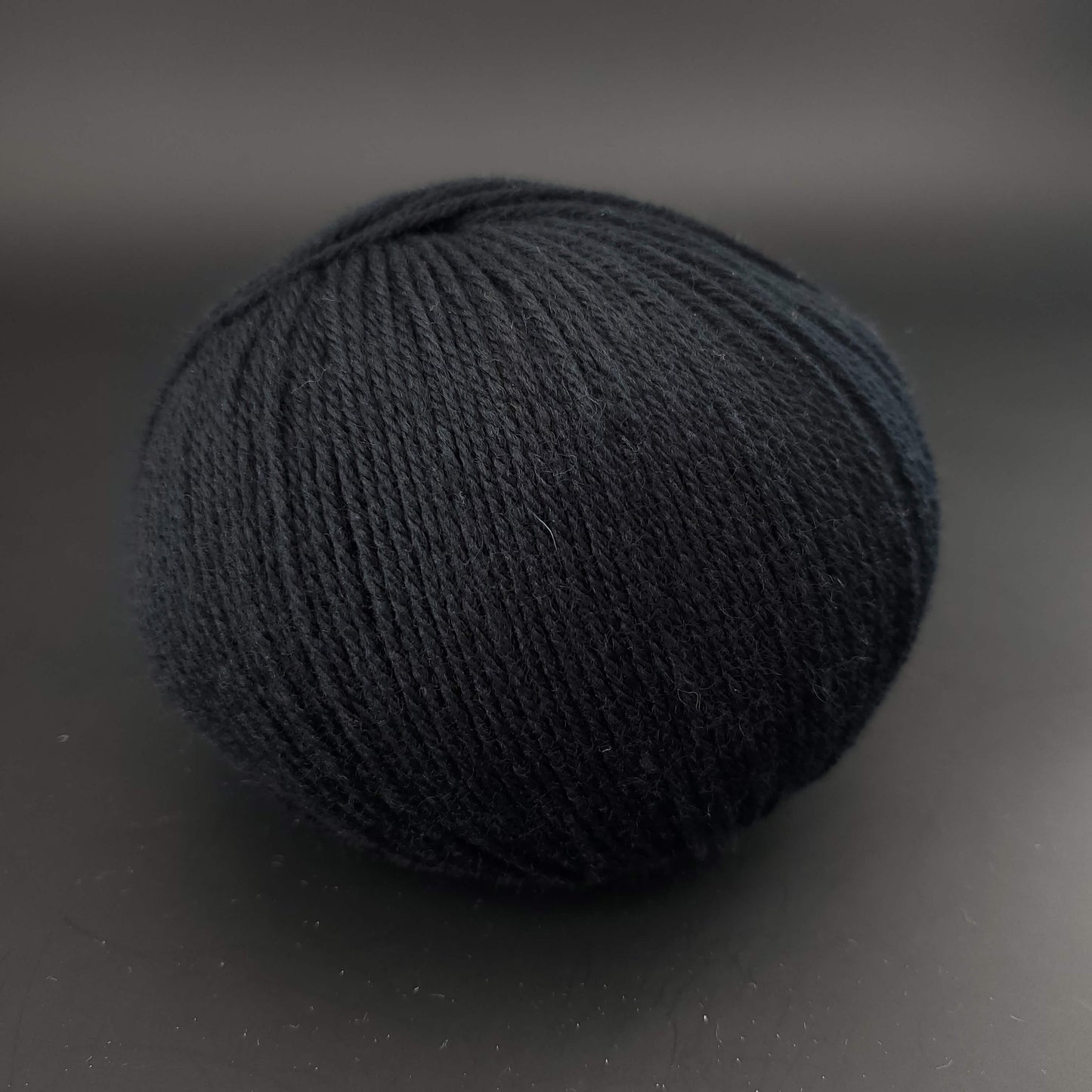 Pelote de laine the merry merino 220 de kremke coloris 21 noir sur fond noir