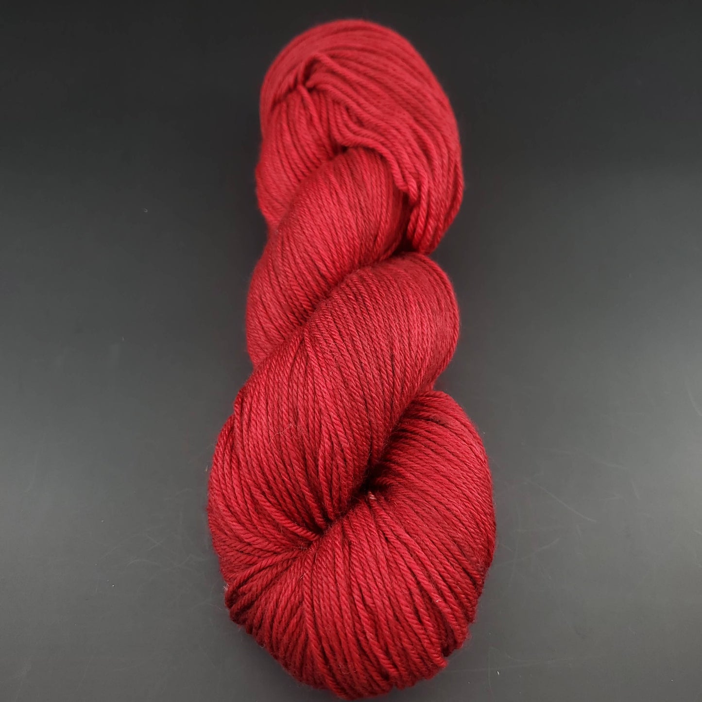 Echeveau de laine Malabrigo Arroyo de couleur 033 cereza sur fond noir pour tricot et crochet