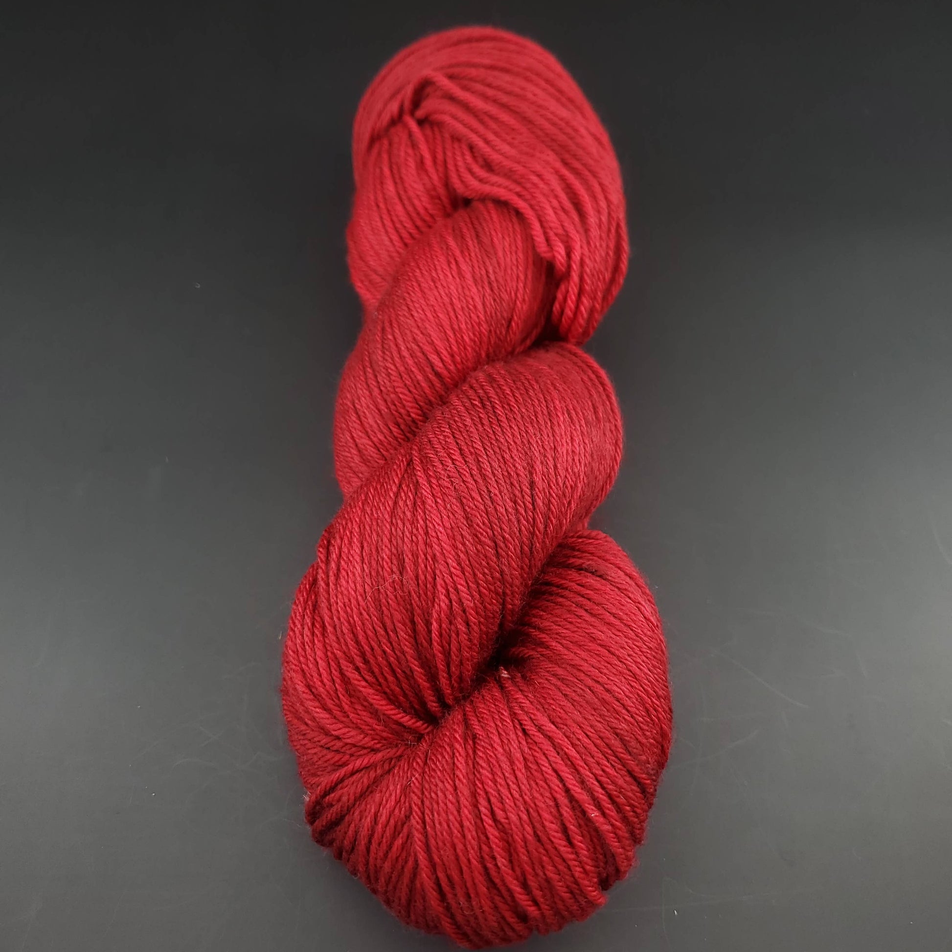 Echeveau de laine Malabrigo Arroyo de couleur 033 cereza sur fond noir pour tricot et crochet