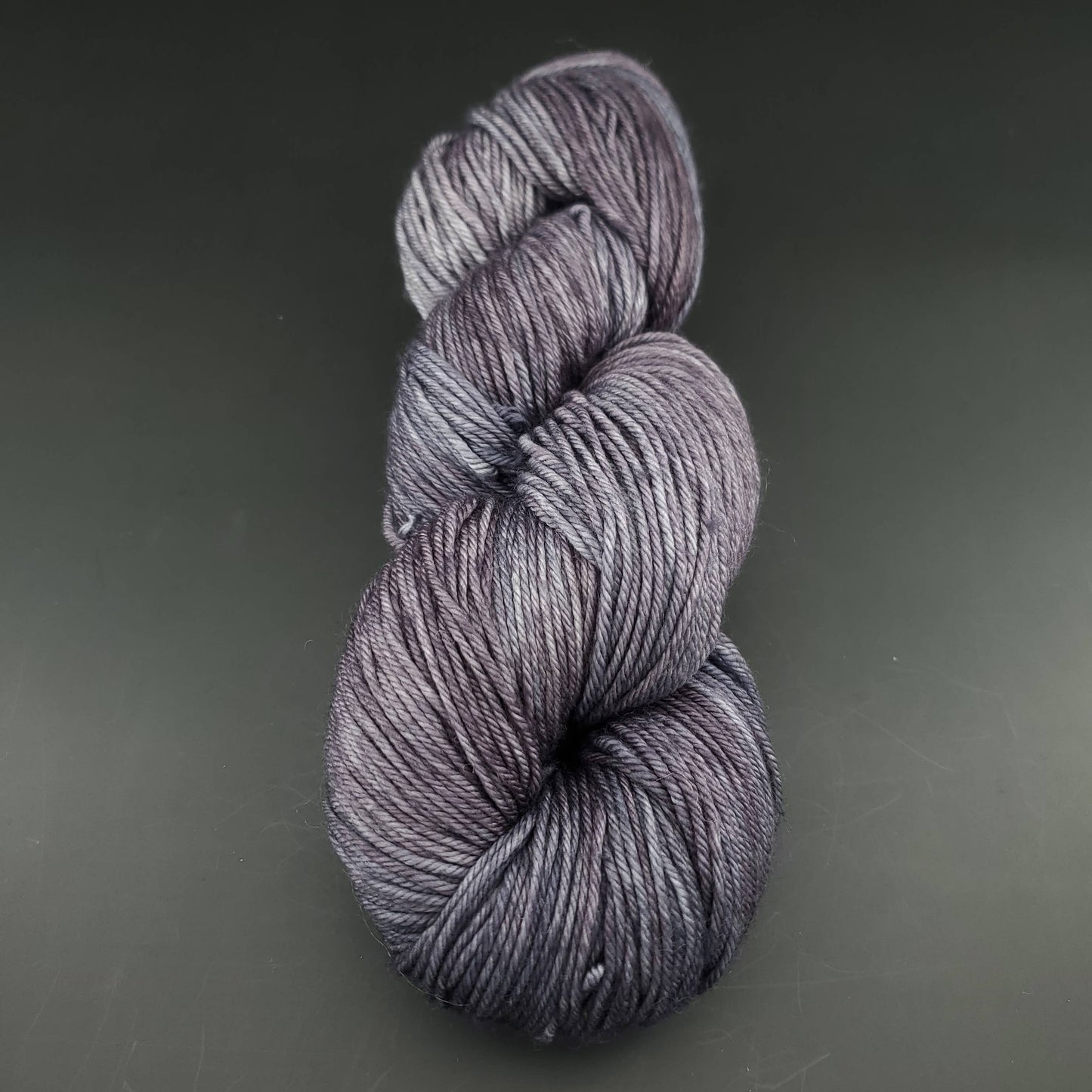 Echeveau de laine Malabrigo Arroyo de couleur 043 plomo sur fond noir pour tricot et crochet