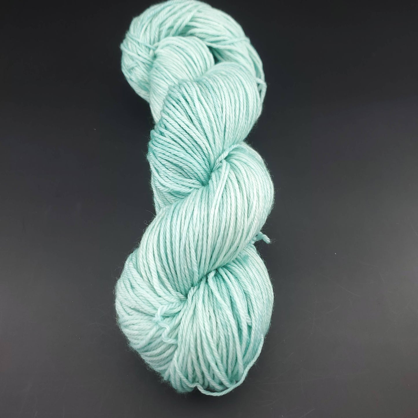 Echeveau de laine Malabrigo Arroyo de couleur 083 water green sur fond noir pour tricot et crochet