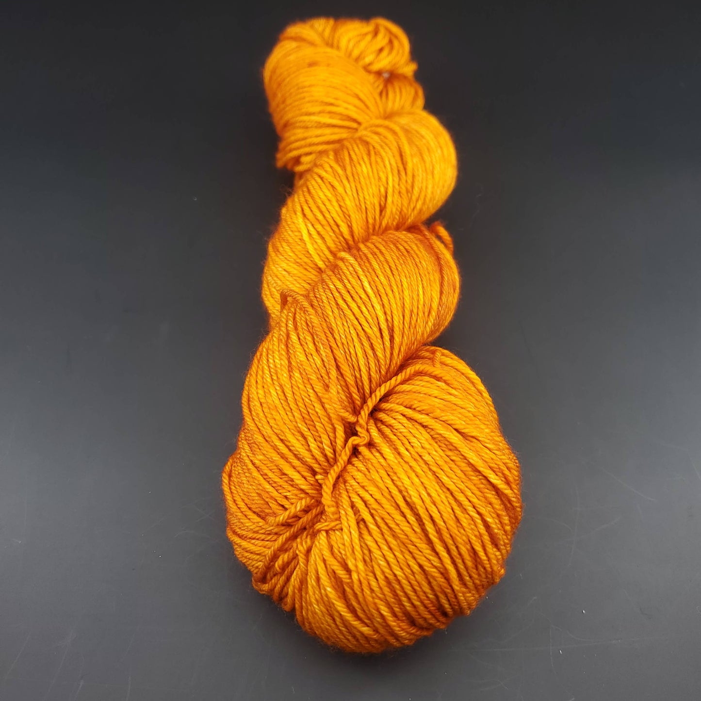 Echeveau de laine Malabrigo Arroyo de couleur 096 sunset sur fond noir pour tricot et crochet