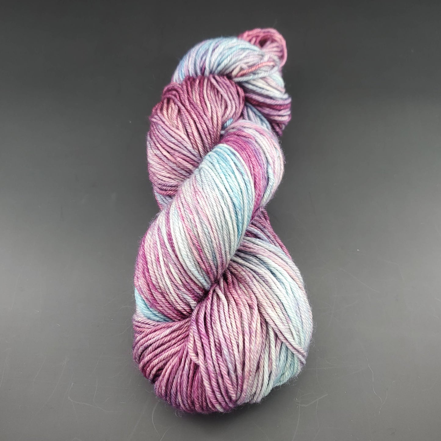 Echeveau de laine Malabrigo Arroyo de couleur 120 lotus sur fond noir pour tricot et crochet