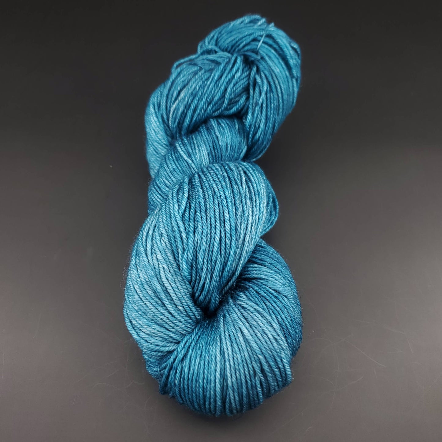 Echeveau de laine Malabrigo Arroyo de couleur 133 reflecting pool sur fond noir pour tricot et crochet