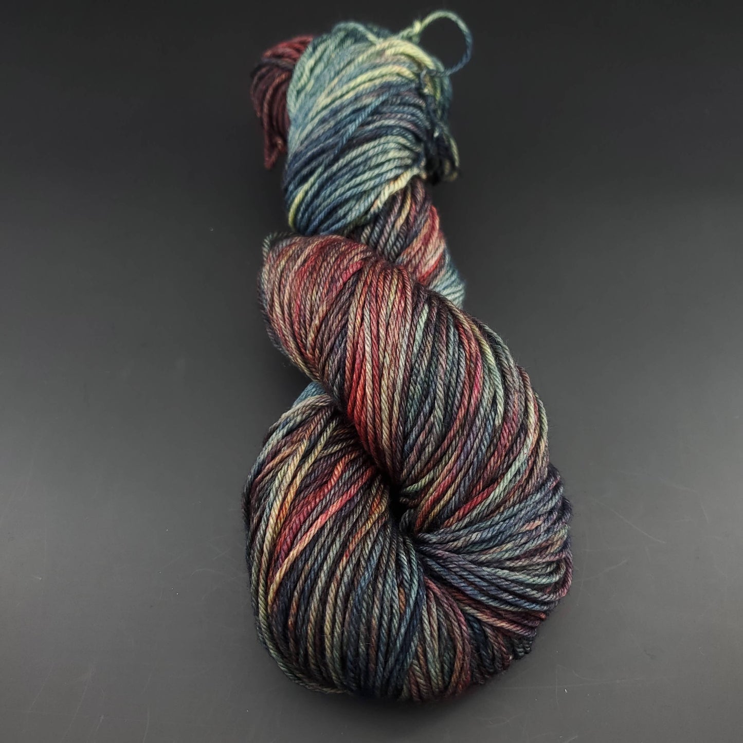 Echeveau de laine Malabrigo Arroyo de couleur 139 pocion sur fond noir pour tricot et crochet