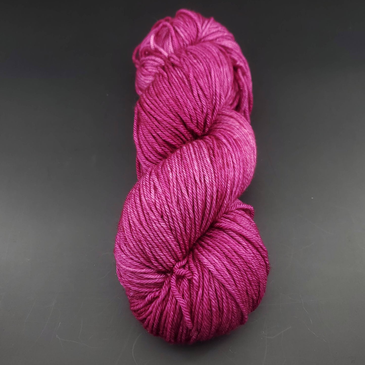 Echeveau de laine Malabrigo Arroyo de couleur 148 hollyhock sur fond noir pour tricot et crochet