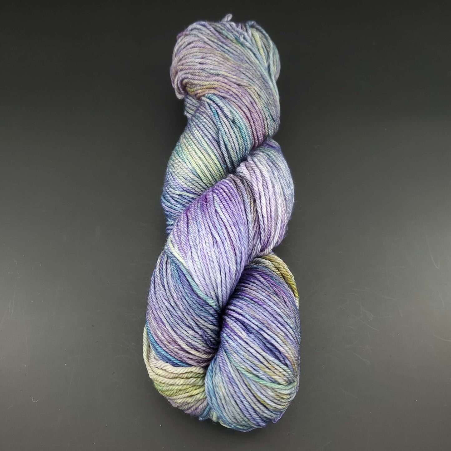 Echeveau de laine Malabrigo Arroyo de couleur 416 indiecita sur fond noir pour tricot et crochet