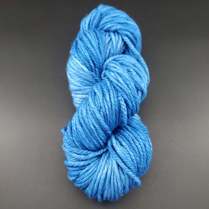 Echeveau de laine Malabrigo Chunky de couleur 026 continental blue sur fond noir pour tricot et crochet.