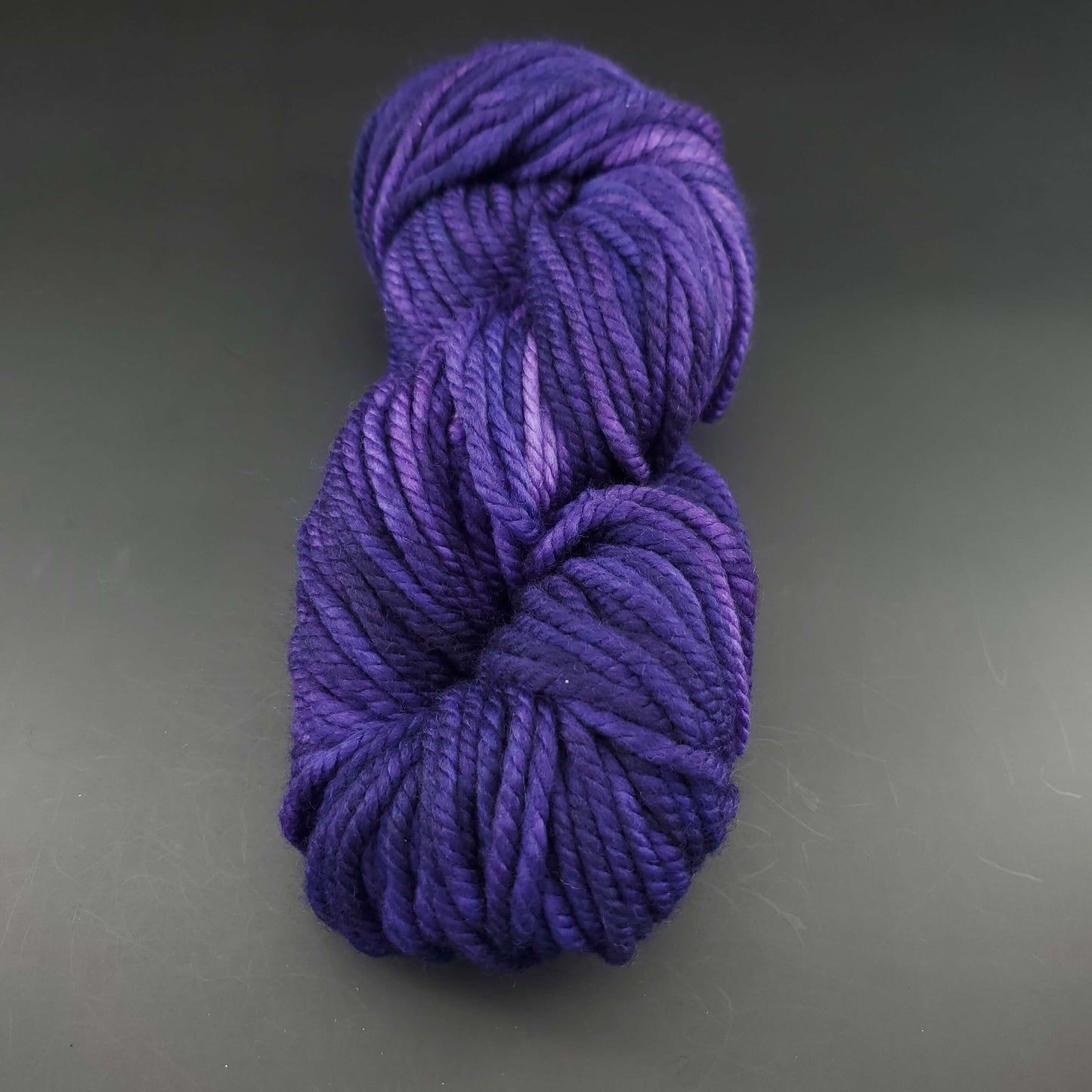 Echeveau de laine Malabrigo Chunky de couleur 030 purple mystery sur fond noir pour tricot et crochet.