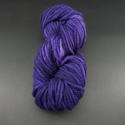 Echeveau de laine Malabrigo Chunky de couleur 030 purple mystery sur fond noir pour tricot et crochet.