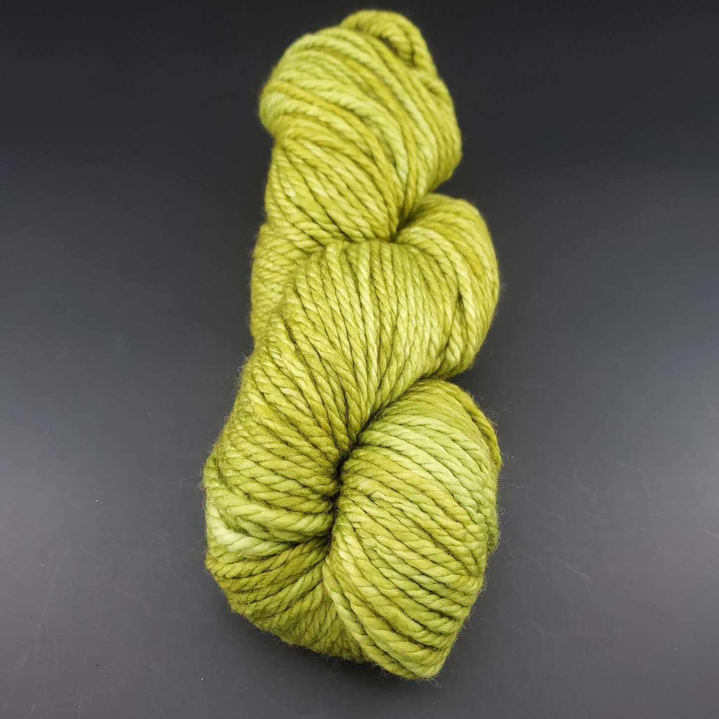 Echeveau de laine Malabrigo Chunky de couleur 037 lettuce sur fond noir pour tricot et crochet.