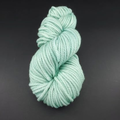 Echeveau de laine Malabrigo Chunky de couleur 083 water green sur fond noir pour tricot et crochet.